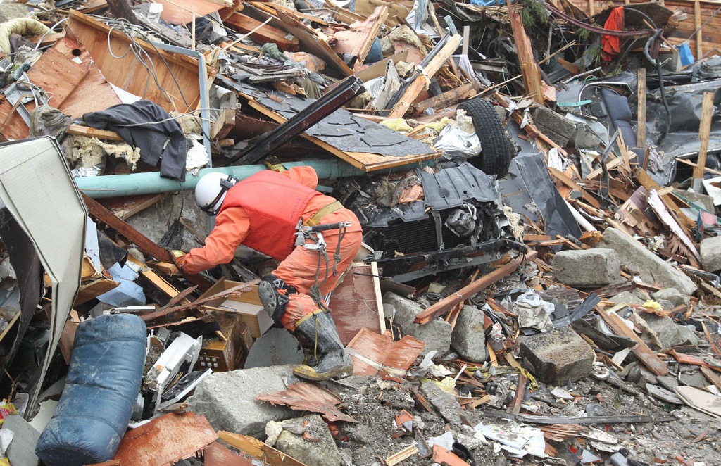 Relief worker searching for life underneath the rubble